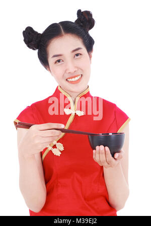 Glückliche Frau tragen chinesische cheongsam Kleid mit Essstäbchen und Schüssel auf weißem Hintergrund Stockfoto