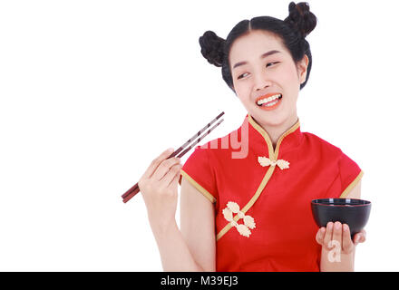 Glückliche Frau tragen chinesische cheongsam Kleid mit Essstäbchen und Schüssel auf weißem Hintergrund Stockfoto