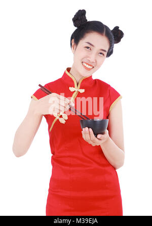 Glückliche Frau tragen chinesische cheongsam Kleid mit Essstäbchen und Schüssel auf weißem Hintergrund Stockfoto