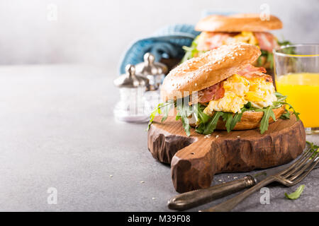 Bagels mit Rührei, Rucola und gebratener Speck Stockfoto