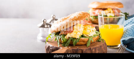 Bagels mit Rührei, Rucola und gebratener Speck Stockfoto