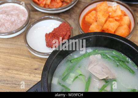 Koreanische Schweinefleisch Reissuppe (Dwaeji - gukbap) in eine dampfende Schüssel mit dem Stein Beilagen im Koreanischen Restaurant, Busan, Südkorea Stockfoto