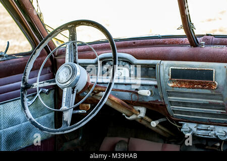 Einrichtung eines alten, verrosteten und verlassenen Plymouth Automobil mit altmodischen Lenkrad mit Segelboot Logo. Stockfoto