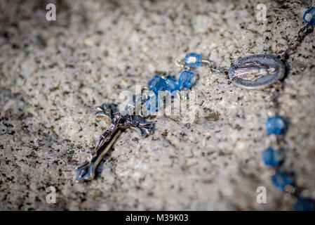 Makro Nahaufnahme eines antiken blau Rosenkranz Verlegung auf Granitfelsen Stockfoto