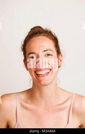 MODEL RELEASED. Junge Frau mit roten Haaren lächelnd. Stockfoto