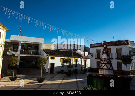 Ansichten von der Mitte der weißen Dorf Benaojan in Malaga mit Weihnachtsdekoration. Cute Marktplatz mit dem Rathaus und kleinen Häusern. Stockfoto