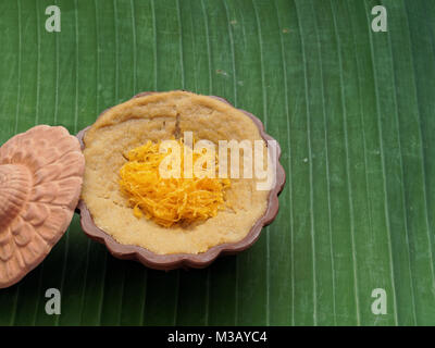 Thailändisches Dessert, Eierstich mit süßen klebrigen Reis garniert mit goldenen Fäden, auf Banana leaf Hintergrund Stockfoto