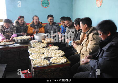 (180210) - Peking, Februar 10, 2018 (Xinhua) - Datei Foto am 31.01.30. 2014 zeigt die Dorfbewohner, Jiaozi, oder Chinesische Knödel, in Xigaze Puxia Dorf, der Südwesten Chinas Tibet autonomen Region. Familientreffen Abendessen oder den Neujahrsdinner, ist das wichtigste Dinner für Chinesisch in einem ganzen Jahr, wenn alle Mitglieder der Familie zusammen und die Freude an der Begrüßung ein neues Jahr teilen. Spring Festival, oder besser als chinesische Mondjahr genannt, ist das wichtigste Festival für alle Chinesen, die hat eine Geschichte von mehr als 4.000 Jahren. Es ist eine Gelegenheit für zu Hause neues Jahr gehen Stockfoto