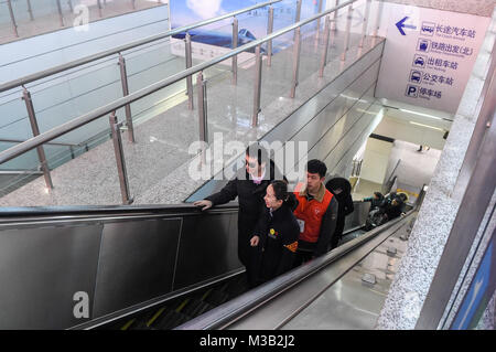 Nanjing in der chinesischen Provinz Jiangsu. 9 Feb, 2018. Chen Deyu (1. L) tritt in den Shanghai South Railway Station mit Hilfe der ein Verwalter und ein Freiwilliger in Nanjing, der Hauptstadt der ostchinesischen Provinz Jiangsu, Feb 9, 2018. Chen Deyu, einem blinden Masseur Geboren 1988, erhielt Hilfe von der '158' Freiwilligendienst Gruppe der Nanjing South Railway Station von Nanjing in seine Heimatstadt in Anhui. Die Gruppe, im Jahr 1968, ist auf die Unterstützung der abzielen müssen sich auf ihren Reisen. Credit: Li Bo/Xinhua/Alamy leben Nachrichten Stockfoto