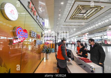 Nanjing in der chinesischen Provinz Jiangsu. 9 Feb, 2018. Chen Deyu (1. R) ist auf dem Stand des '158' Freiwilligendienst Gruppe in Nanjing, der Hauptstadt der ostchinesischen Provinz Jiangsu, Feb 9, 2018 gesehen. Chen Deyu, einem blinden Masseur Geboren 1988, erhielt Hilfe von der '158' Freiwilligendienst Gruppe der Nanjing South Railway Station von Nanjing in seine Heimatstadt in Anhui. Die Gruppe, im Jahr 1968, ist auf die Unterstützung der abzielen müssen sich auf ihren Reisen. Credit: Li Bo/Xinhua/Alamy leben Nachrichten Stockfoto