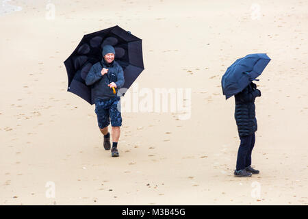 Bournemouth, Dorset, Großbritannien. 10. Februar, 2018. UK Wetter: Eine nasse windigen miserablen Tag in Bournemouth - Menschen kämpfen mit ihren Sonnenschirme am Strand versucht, trocken zu bleiben! Credit: Carolyn Jenkins/Alamy leben Nachrichten Stockfoto