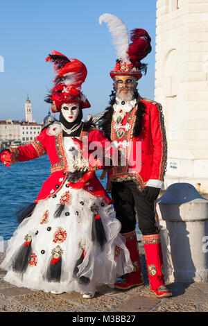 Venedig, Venetien, Italien, 10. Februar 2018. Bunte Kostüme beim Karneval in Venedig an einem sonnigen Tag am letzten Wochenende des Festivals. Menschen auf die Insel San Giorgio Maggiore bei Sonnenuntergang posieren. Stockfoto