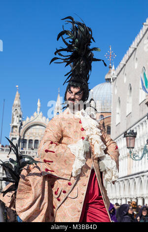 Venedig, Venetien, Italien, 10. Februar 2018. Bunte Kostüme beim Karneval in Venedig an einem sonnigen Tag am letzten Wochenende des Festivals. Man posiert alongisde der Dogenpalast in Piazzetta San Marco. Stockfoto