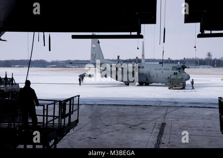 Flieger guide C-130H Hercules in den Hangar ein isochroner Inspektion der vor kurzem erworbenen Flugzeuge, zu beginnen, 08.02.2018, an der 179th Airlift Wing, Mansfield, Ohio. Schwanz 666 wurde vor Kurzem von Yakota Airbase, Japan übertragen werden, und wird die Mansfield schwanz Markierungen während der ISO-Prozess, der eine umfangreiche Auswertung der ganzen Maschine einwandfreie Funktionalität und Mission Bereitschaft zu gewährleisten. (U.S. Air National Guard Foto von Tech. Sgt. Joe HarwoodReleased) Stockfoto