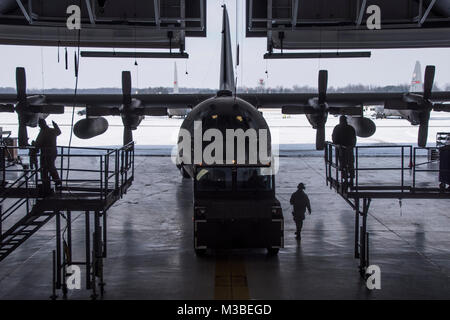 Flieger guide C-130H Hercules in den Hangar ein isochroner Inspektion der vor kurzem erworbenen Flugzeuge, zu beginnen, 08.02.2018, an der 179th Airlift Wing, Mansfield, Ohio. Schwanz 666 wurde vor Kurzem von Yakota Airbase, Japan übertragen werden, und wird die Mansfield schwanz Markierungen während der ISO-Prozess, der eine umfangreiche Auswertung der ganzen Maschine einwandfreie Funktionalität und Mission Bereitschaft zu gewährleisten. (U.S. Air National Guard Foto von Tech. Sgt. Joe HarwoodReleased) Stockfoto