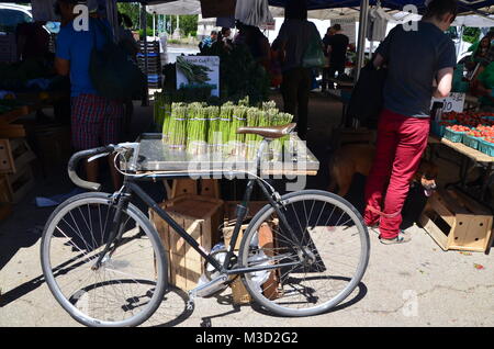 Ein Rennrad hielten gegen eine Spargel Grand Army Plaza Farmer's Market Brooklyn Park Slope New York USA Abschaltdruck Stockfoto