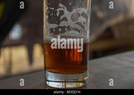 Glas halb voll oder halb leer Bier Stockfoto