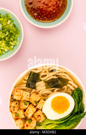 Im japanischen Stil vegetarisch Tofu Nudeln Ramen Suppe oder Brühe gegen eine blass rosa Hintergrund Stockfoto