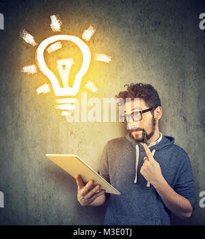 Casual junger Student mit Tablet und neue Idee. Stockfoto