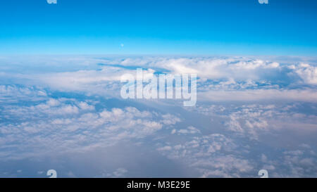 Luftaufnahme von weiße Wolkenformationen mit Mond im Horizont Stockfoto