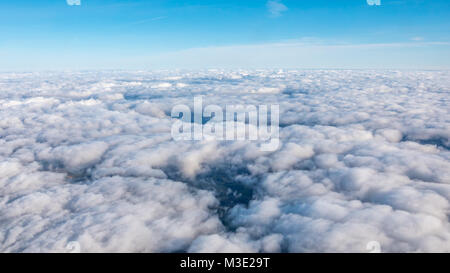 Blick auf die Flecken des Landes durch eine dichte Wolkendecke Stockfoto