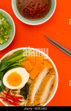 Im japanischen Stil Panko Paniermehl Hähnchen und Nudelsuppe Brühe oder Suppe mit Süßkartoffeln auf rotem Hintergrund Stockfoto