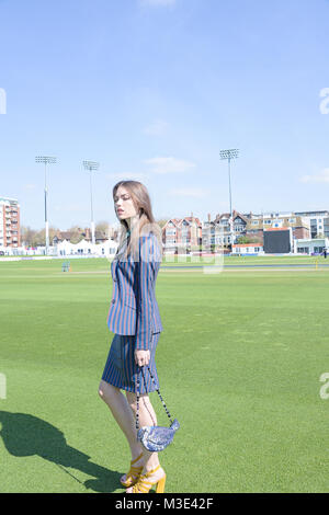 Ein schönes Mädchen mit einem maßgeschneiderten stilvolle gemusterten Anzug ist in einem Cricket Ground an einem schönen hellen Tag - sie ist zuversichtlich und durchsetzungsfähige Stockfoto