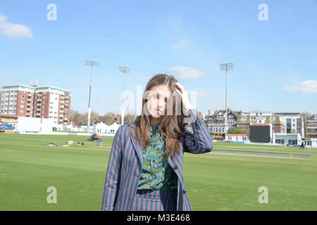 Ein schönes Mädchen mit einem maßgeschneiderten stilvolle gemusterten Anzug ist in einem Cricket Ground an einem schönen hellen Tag - sie ist zuversichtlich und durchsetzungsfähige Stockfoto