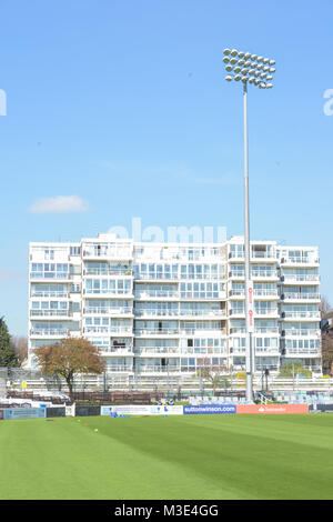 Einige Wohnungen an der Rückseite der Hove Cricket Ground suchen im Sonnenlicht mit dem Cricket grün vor schönen Stockfoto