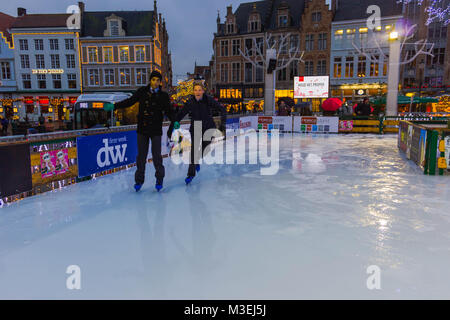 Brügge, Belgien - 13 Dezember, 2017: Die Menschen Schlittschuhlaufen auf der Eisbahn am Marktplatz Stockfoto