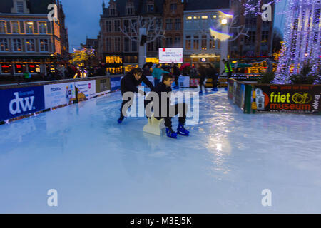 Brügge, Belgien - 13 Dezember, 2017: Die Menschen Schlittschuhlaufen auf der Eisbahn am Marktplatz Stockfoto