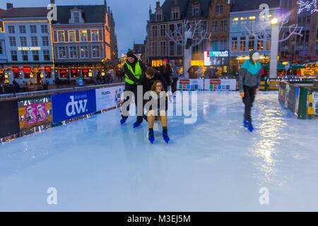 Brügge, Belgien - 13 Dezember, 2017: Die Menschen Schlittschuhlaufen auf der Eisbahn am Marktplatz Stockfoto