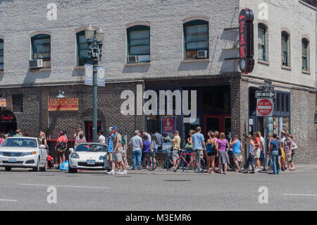 Portland, Oregon - 24. Juli. 2010: Voodoo Donuts ist ein sehr beliebtes Donut Shop, der häufig eine Linie des Kunden warten. Stockfoto