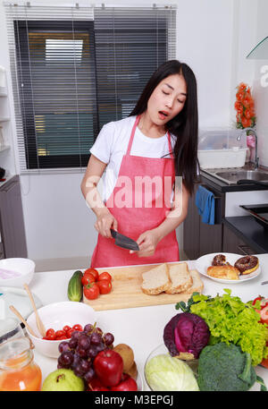 Frau hat sich in den Finger geschnitten, beim Kochen in der Küche Zimmer zu Hause Stockfoto