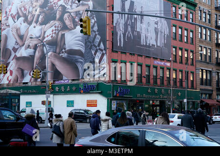 Bau Gerüste und Werbung mit Reklametafeln mit Fußgängern bei E.Houstion Street und Crosby Street in SoHo Bereich. Manhattan, New York City, USA. Stockfoto