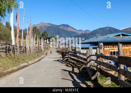 Phobjikha, Bhutan. Gebetsfahnen und Häuser eine lokale Straße in der Phobjikha Tal. Stockfoto