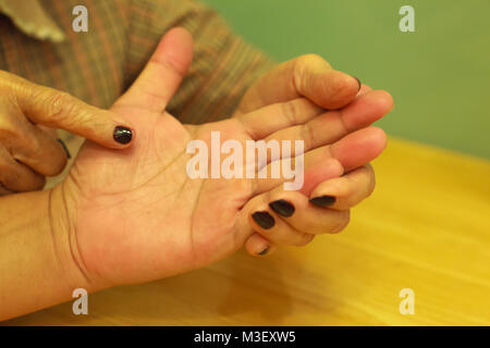 Alte Frau erzählt Fortune für junge Menschen durch Palm lesen. Palm lesen, Handlesen Konzept. Stockfoto