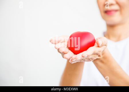 Selektiver Fokus der roten Herzen von lächelnden Frau Krankenschwester sowohl die Hand, die Ihnen alle Bemühung, qualitativ hochwertigen Service zu Patienten zu liefern. Stockfoto