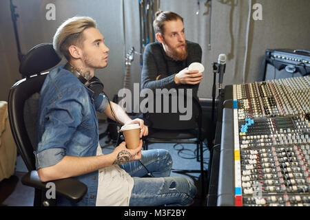 Tontechniker mit Kaffee arbeiten im Tonstudio Stockfoto