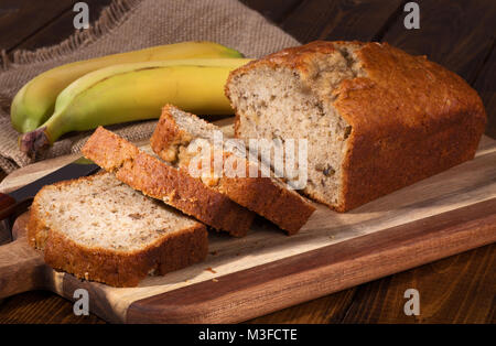 Banane Mutter süßes Brot in Scheiben geschnitten auf einer hölzernen Schneidebrett Stockfoto