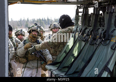 Sgt. Jourdain Ritter, einem Fluglehrer mit C, 2-10 Assault Helicopter Bataillon, 10 Combat Aviation Brigade, 10 Mountain Division (LI), führt eine Sicherheit für die Soldaten, die kurz vor einem Air Assault Schulung und Betrieb in Fort Drum, New York, am 2. Februar. Die Air Assault Operation dauerte sechs Tage, mit Fliegern Ausbildung und die Ausführung der Bewegung der Luft mit drei Unternehmen der Soldaten aus 2 Battalion, 87th Infantry Regiment, 2nd Brigade Combat Team, 10-Mountain Division (LI). (U.S. Armee Stockfoto