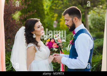 Portrait von glücklichen Paare tauschen Ringe während ihrer Trauung im Freien Stockfoto