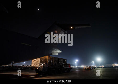 Antenne Transport team Personalarbeit Cargo von der US Air Force C-17 Globemaster III bei Bagram Air Field, Afghanistan, Jan. 24, 2018 zu entladen. Der C-17 ist in der Lage, rasche strategische Bereitstellung von Truppen und alle Arten von Fracht zu Grundlagen der gesamten US Central Command Verantwortungsbereich. Das Flugzeug ist ausgerüstet sein taktischer Lufttransport, airdrop und medizinischem wie Missionen erfordern. (U.S. Air Force Stockfoto