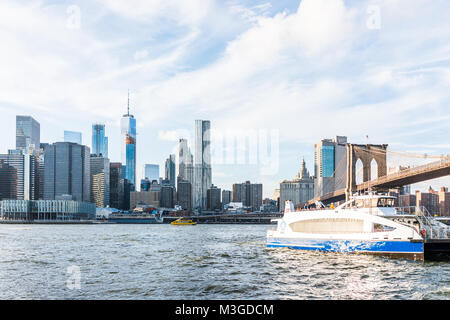 Brooklyn, USA - Oktober 28, 2017: East River Wasser mit Blick auf NEW YORK CITY New York City Skyline Skyline, Brücke, Schiff, Fähre schwimmen durch niedrigere financi Stockfoto