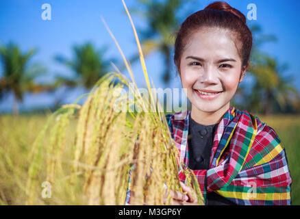 Bauer Frau mit Reis im Feld, Thailand Stockfoto