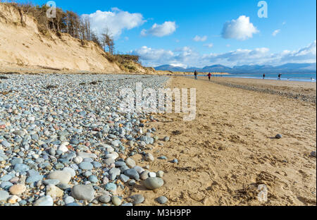 Blick von llanddwyn Beach auf Anglesey in Richtung der schneebedeckten Berge von Snowdonia Stockfoto