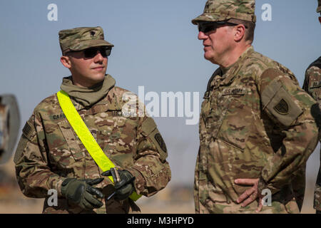 Spezialist Carlos Caro, ein Transport Management Coordinator, 625 Bewegung steuern, erklärt Umladestellen Operationen Generalmajor Mark Palzer, Kommandierender General, 79th Sustainment unterstützt den Befehl, an der Kreuzung auf dem Khabari Kuwait-Iraq Grenze, Feb 4, 2018, während der Gemeinsamen monatlichen Zugang für Reserve Komponente (JMARC), vierteljährlich eine Chance für Führungskräfte aus der U.S. Army National Guard und Finden mit eingesetzten Soldaten zu besuchen. Die JMARC bot die Möglichkeit zu finden, die den Einsatz der Mission auf zukünftige Einheiten vorbereitet werden, durch richtige Manning sicher zu verstehen, e Stockfoto