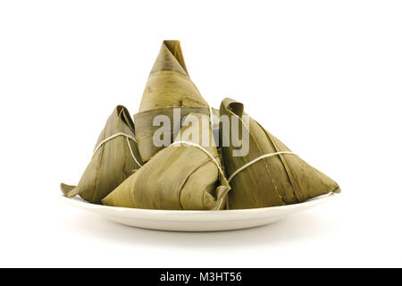 Traditionelle gewickelt Reis Knödel oder zongzi auf einem Teller, auf weißem Hintergrund Stockfoto