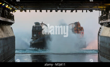 Atlantik (Feb. 9, 2018) eine Landing Craft, Luftkissen (LCAC), angeschlossen an Angriff Craft Unit (ACU) 4, trägt das Deck des Amphibious Assault ship USS Iwo Jima (LHD7). Die Iwo Jima Amphibious Ready Gruppe begibt sich die 26 Marine Expeditionary Unit und umfasst die Iwo Jima, die amphibious Transport dock Schiff USS New York (LPD-21), das Dock Landung Schiff USS Oak Hill (LSD 51), Flotte Op-Team 8, Hubschrauber Meer Combat Squadron 28, Tactical Air Control Squadron 22, Komponenten der Naval Beach Gruppe 2 und die begonnen, Mitarbeiter der Amphibischen Squadron 4. (U.S. Marine Foto durch Massenmedien. Stockfoto