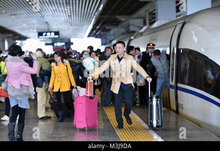 (180211) - Peking, Februar 11, 2018 (Xinhua) - Datei Foto auf Jan. 24, 2016 zeigt einen Passagier für ein Foto mit einem Schnellzug bei Guangzhou South Railway Station in Guangzhou, Provinz Guangdong im Süden Chinas posieren. Egal, welche Transportmittel Sie nehmen, alle Chinesischen der einzige Wunsch, den während des Frühlings Festival reisen Rush - Rückkehr nach Hause. Die spektakuläre Wanderung der Bevölkerung jedes Jahr in China spiegelt auch die Entwicklung der Gesellschaft und Wirtschaft. Spring Festival, oder besser als chinesische Mondjahr genannt, ist das wichtigste Festival für alle Chinesen, die eine histo Stockfoto